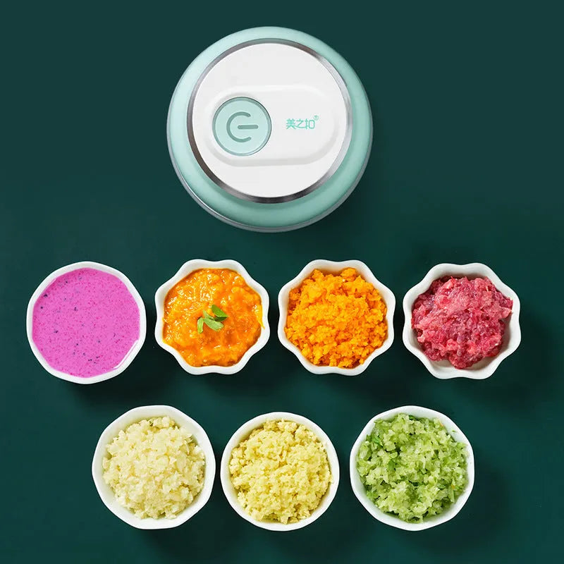 White portable electric food chopper with transparent cup and stainless steel blade on a kitchen counter.