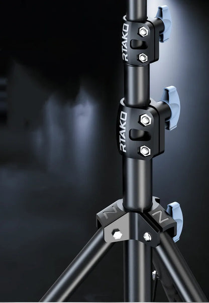 Carbon steel mobile phone tripod extended to full height with a 10-inch lamp attached and phone mounted.