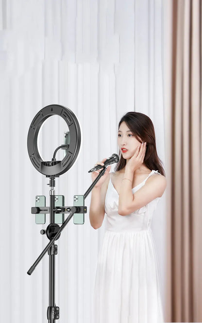 Carbon steel mobile phone tripod extended to full height with a 10-inch lamp attached and phone mounted.