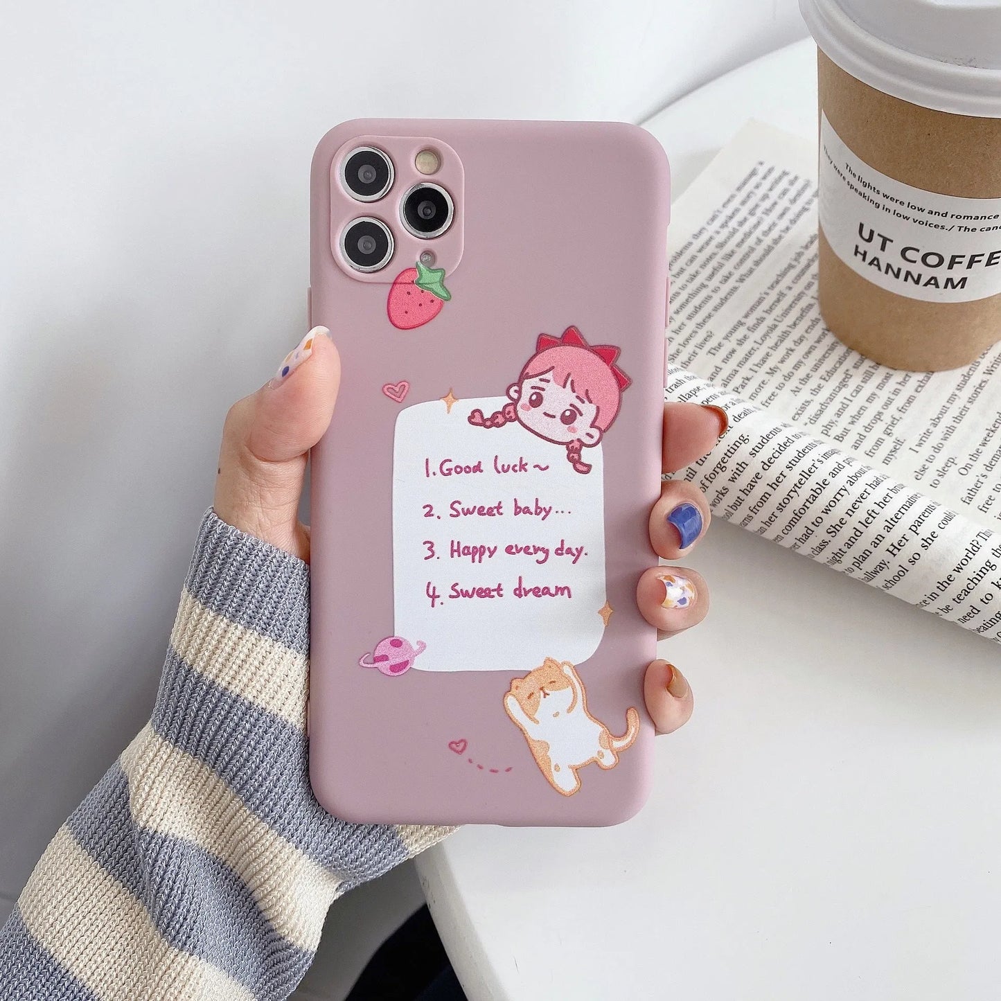 Blue frosted TPU iPhone case with a cartoon dinosaur print next to a pink case with a cat girl print.