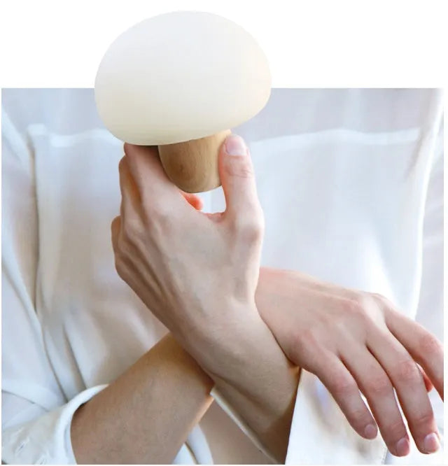 White silicone mushroom-shaped LED night light with a wooden base and touch control.