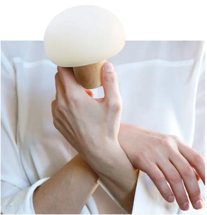 White silicone mushroom-shaped LED night light with a wooden base and touch control.