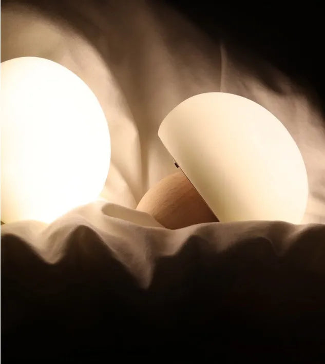 White silicone mushroom-shaped LED night light with a wooden base and touch control.