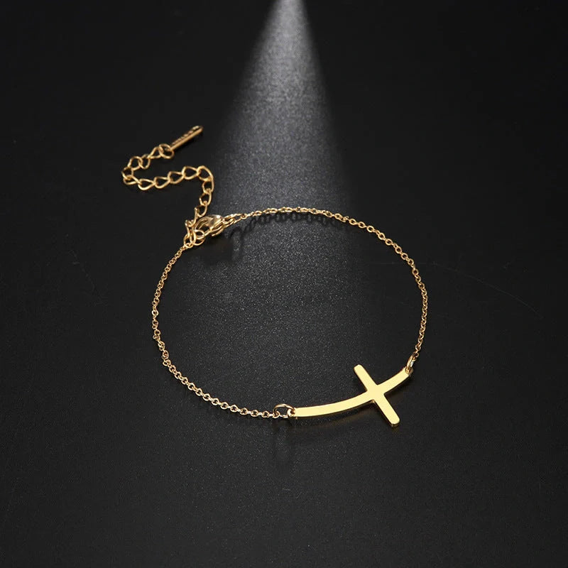 Elegant stainless steel cross pendant bracelet available in steel and gold finishes