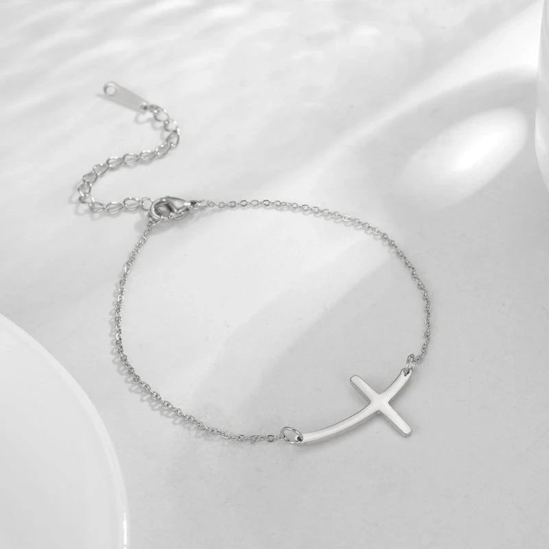 Elegant stainless steel cross pendant bracelet available in steel and gold finishes