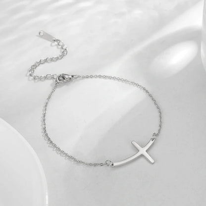 Elegant stainless steel cross pendant bracelet available in steel and gold finishes