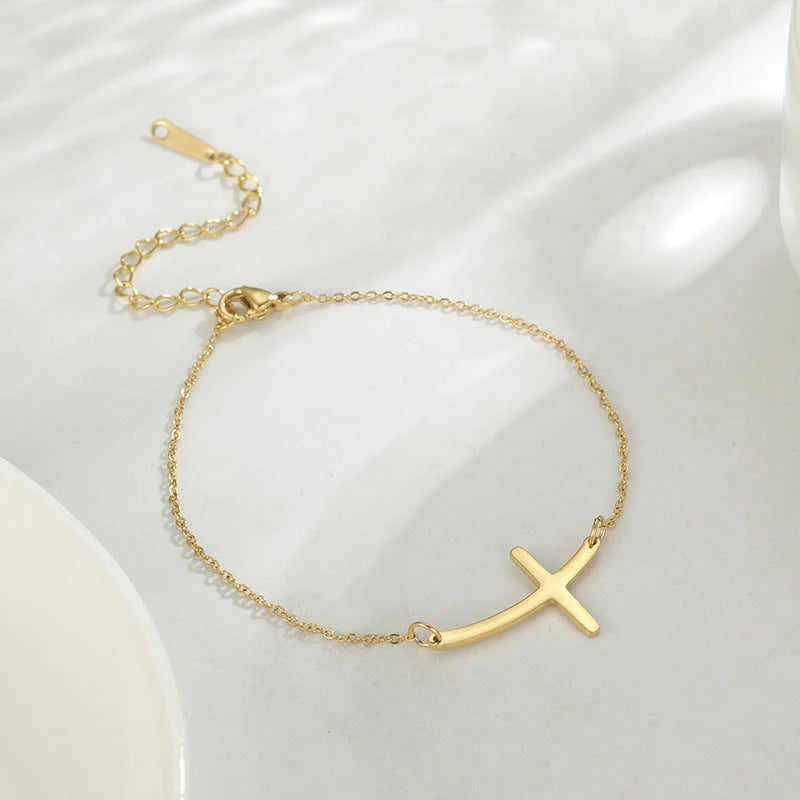 Elegant stainless steel cross pendant bracelet available in steel and gold finishes