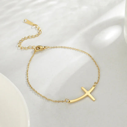 Elegant stainless steel cross pendant bracelet available in steel and gold finishes