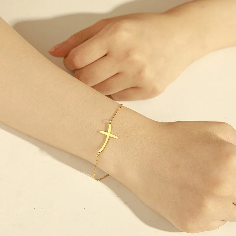 Elegant stainless steel cross pendant bracelet available in steel and gold finishes