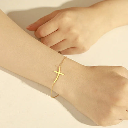 Elegant stainless steel cross pendant bracelet available in steel and gold finishes