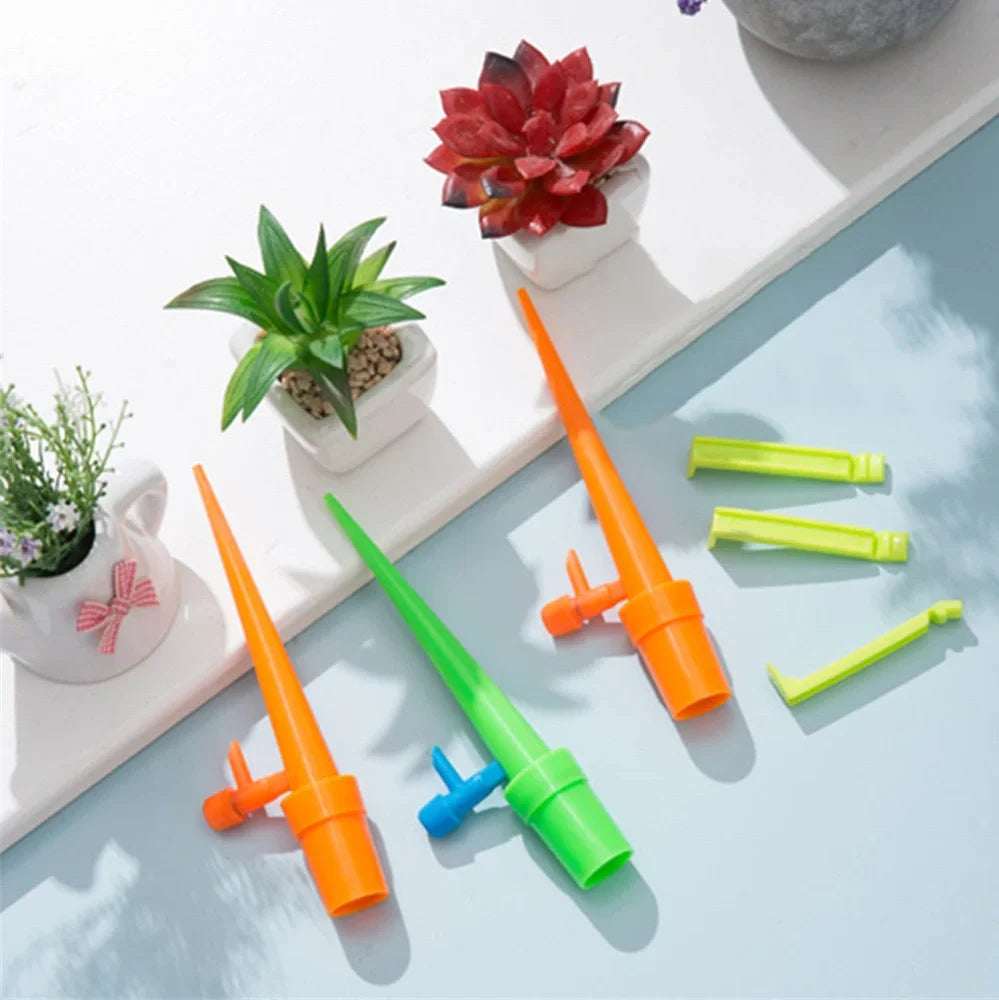 Green and orange plastic garden watering spikes measuring 16.5cm for plant irrigation