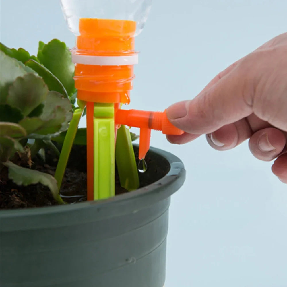 Green and orange plastic garden watering spikes measuring 16.5cm for plant irrigation