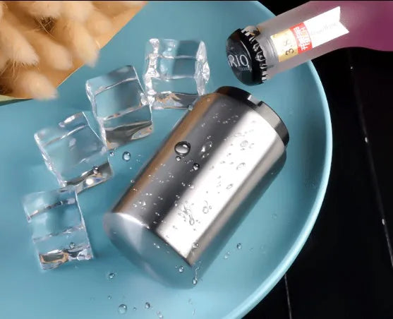 Stainless steel automatic bottle opener measuring 8.4 cm by 5.3 cm on a kitchen counter