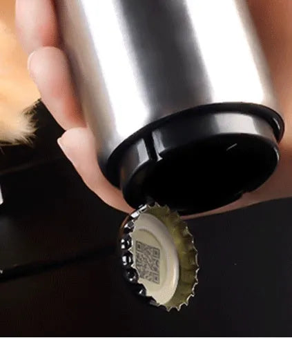Stainless steel automatic bottle opener measuring 8.4 cm by 5.3 cm on a kitchen counter