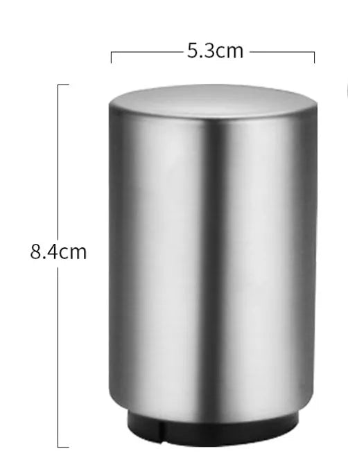 Stainless steel automatic bottle opener measuring 8.4 cm by 5.3 cm on a kitchen counter
