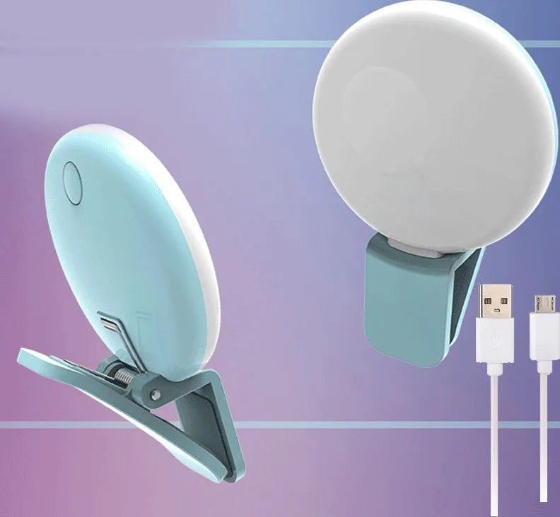 Small round white clip-on LED fill light attached to a mobile phone for selfies.