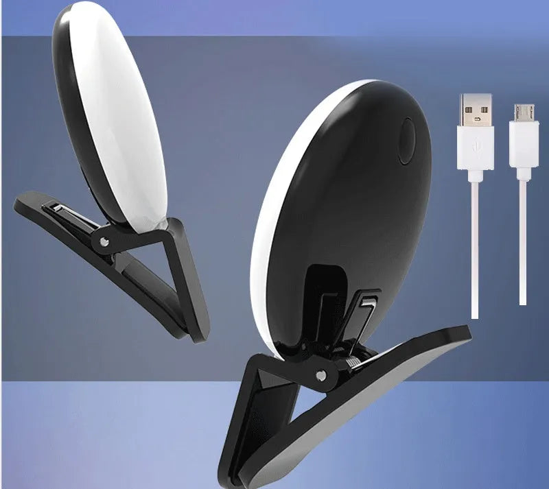Small round white clip-on LED fill light attached to a mobile phone for selfies.
