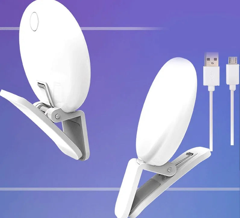 Small round white clip-on LED fill light attached to a mobile phone for selfies.