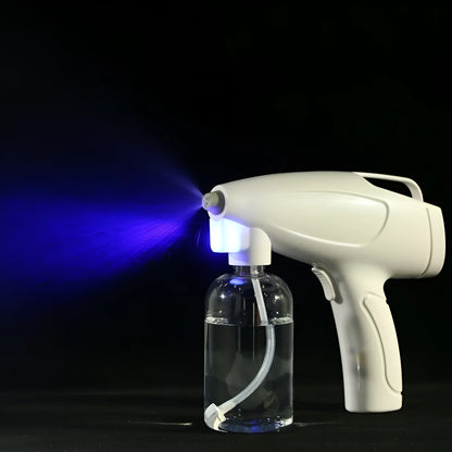 White handheld cordless electric spray disinfection gun with USB-C port and trigger, showing mist spray.