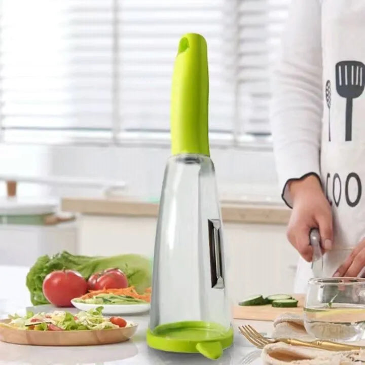 Green vegetable peeler with a transparent storage box attached, showing a stainless steel blade.