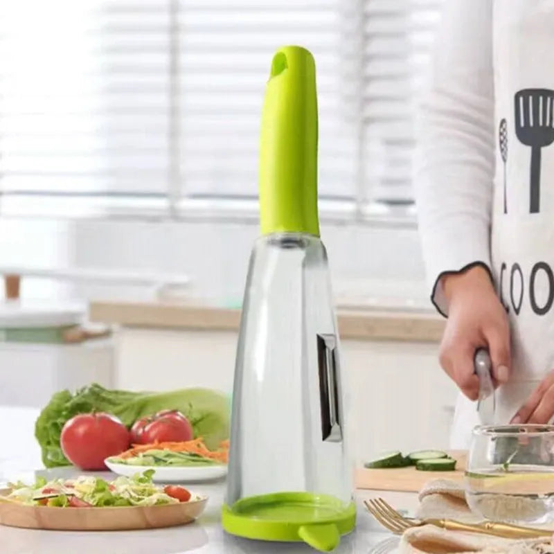 Green vegetable peeler with a transparent storage box attached, showing a stainless steel blade.
