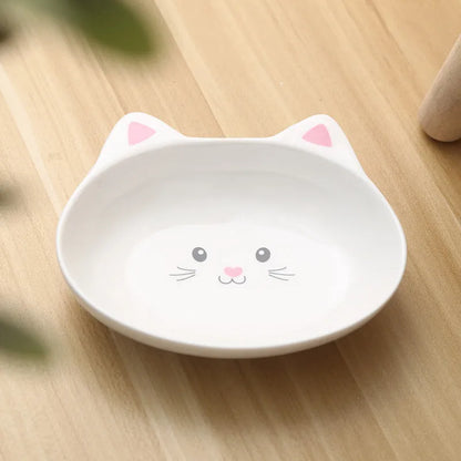 White ceramic pet food bowl with raised cat face design for cats and small dogs