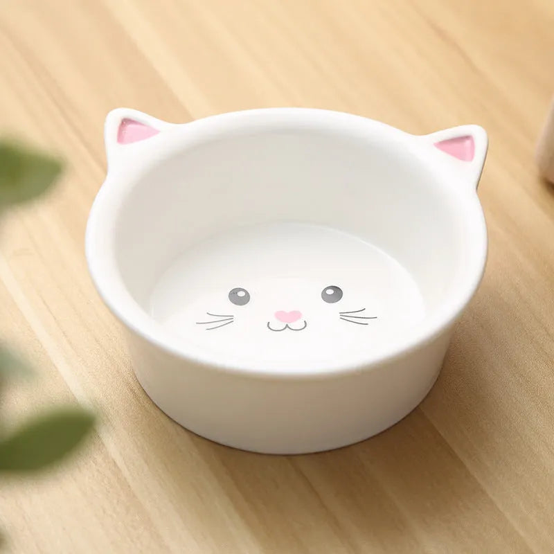 White ceramic pet food bowl with raised cat face design for cats and small dogs