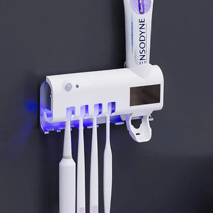 Black wall-mounted UV toothbrush steriliser with automatic toothpaste squeezer showing infrared sensor and solar panel