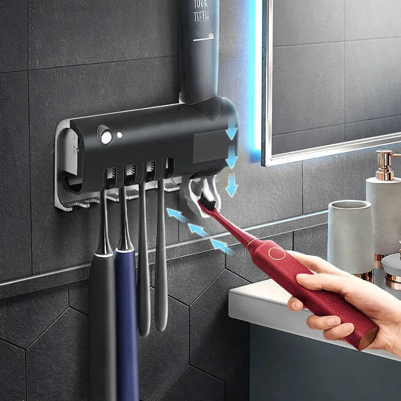 Black wall-mounted UV toothbrush steriliser with automatic toothpaste squeezer showing infrared sensor and solar panel