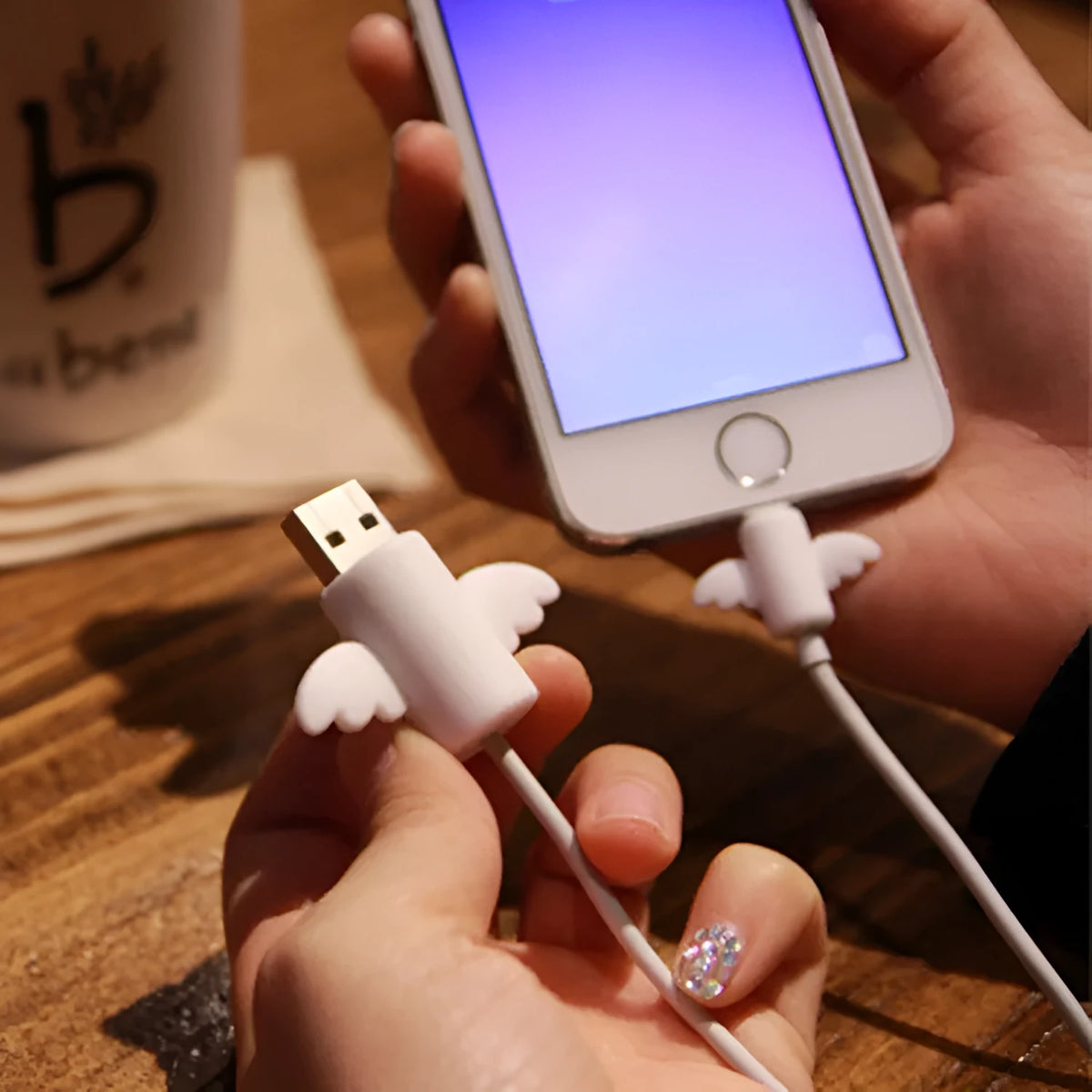 White and black silicone protective covers for mobile phone charging and data cables showing two size options