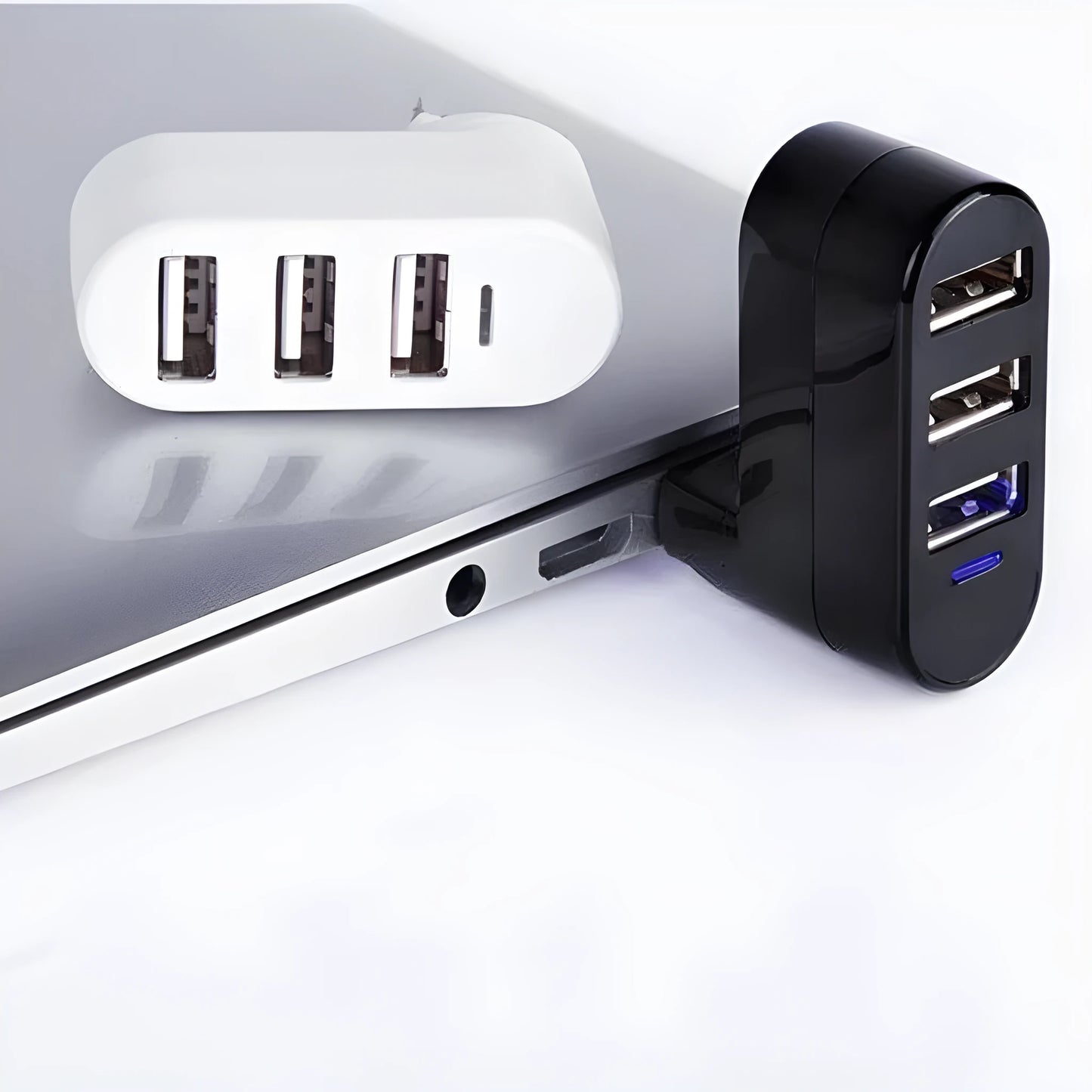 Black and white USB 2.0 hub splitter with spin colour casing on a desk next to a laptop.