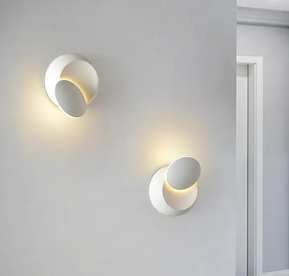 Rotating lunar eclipse LED wall lamp with aluminium shade, pull cord switch, black or white finish, for living room or bedside.
