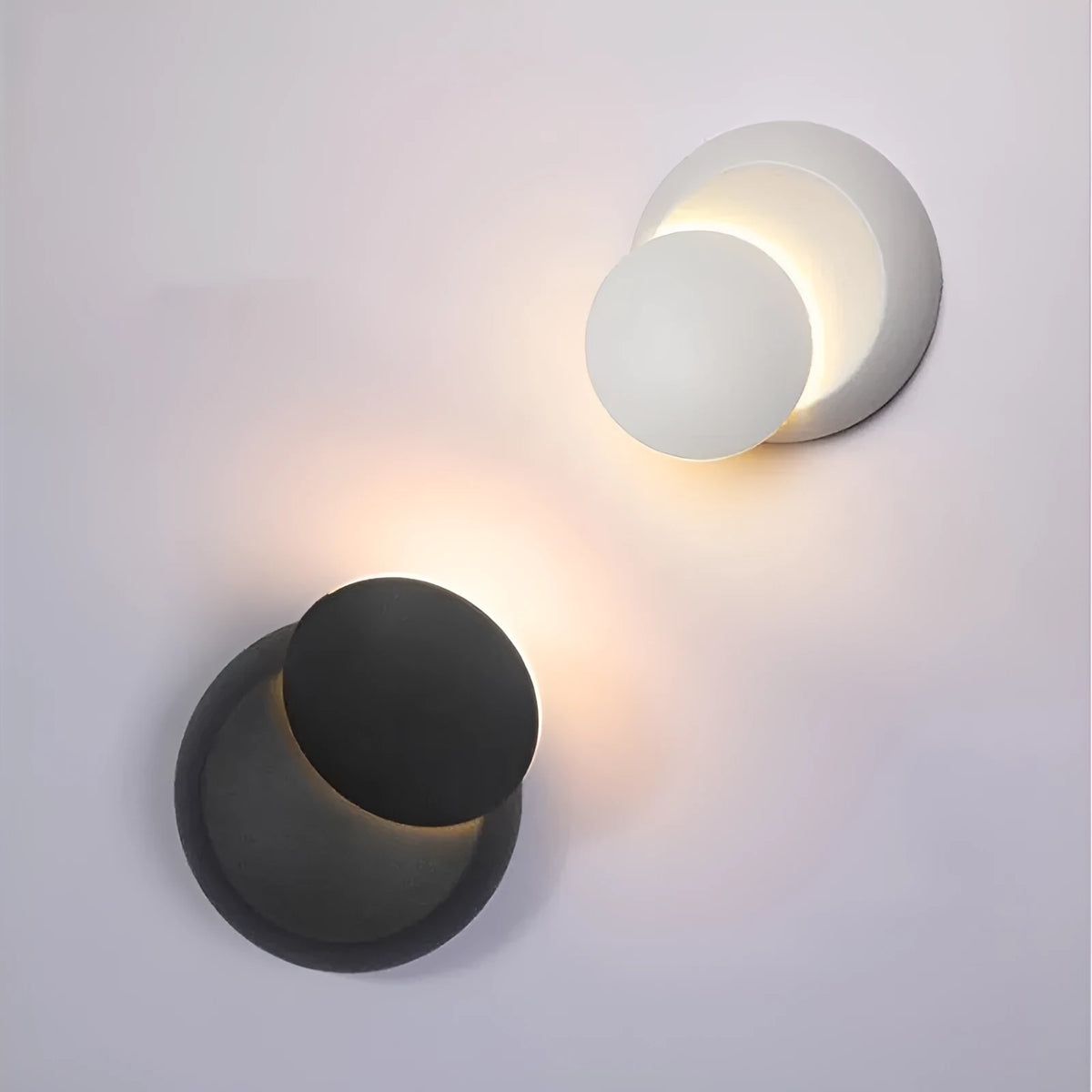Rotating lunar eclipse LED wall lamp with aluminium shade, pull cord switch, black or white finish, for living room or bedside.