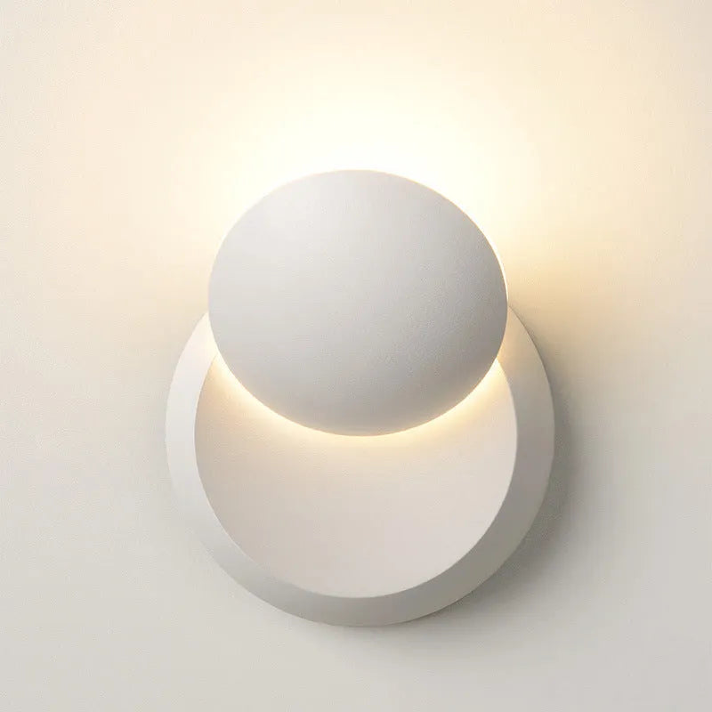 Rotating lunar eclipse LED wall lamp with aluminium shade, pull cord switch, black or white finish, for living room or bedside.