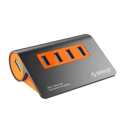 Dark grey and orange aluminium laptop hub with four USB ports, a blue LED light, and a detached cable.