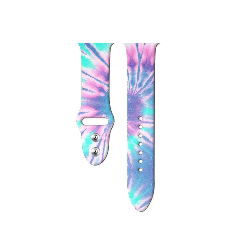Apple Watch silicone band with colourful tie-dye pattern, shown attached to a watch and laid flat