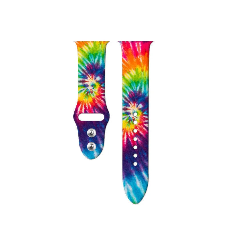 Apple Watch silicone band with colourful tie-dye pattern, shown attached to a watch and laid flat
