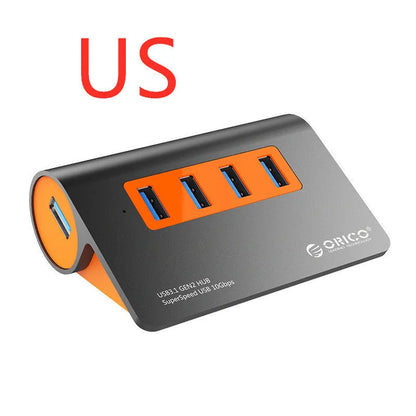Dark grey and orange aluminium laptop hub with four USB ports, a blue LED light, and a detached cable.