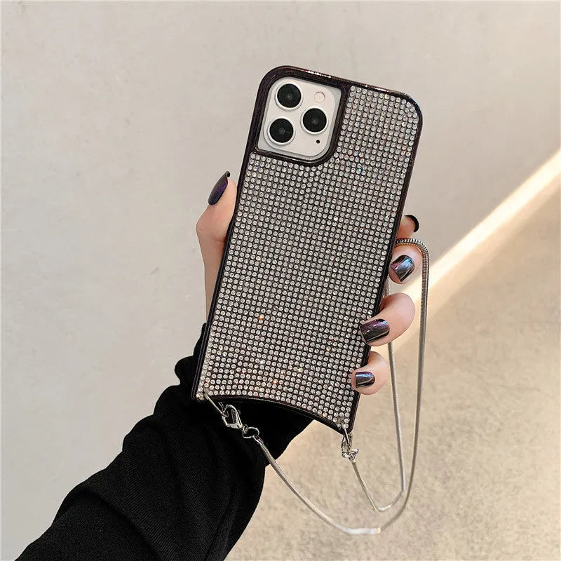 Glitter rhinestone TPU iPhone case with necklace lanyard strap in black, shown on an iPhone 12.