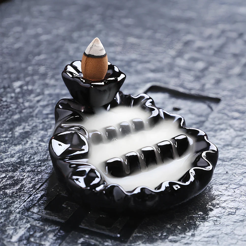 Black ceramic backflow incense burner creating waterfall smoke with sandalwood aroma