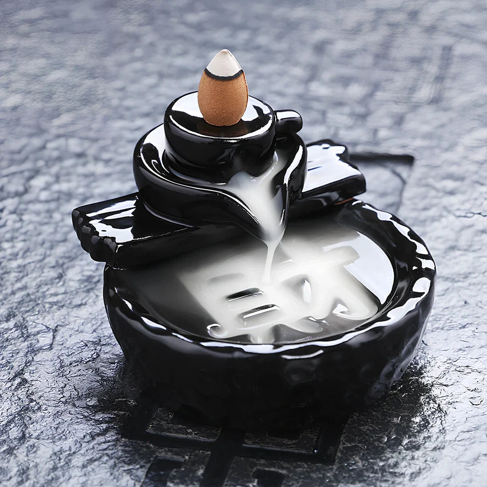 Black ceramic backflow incense burner creating waterfall smoke with sandalwood aroma