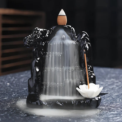 Black ceramic backflow incense burner creating waterfall smoke with sandalwood aroma