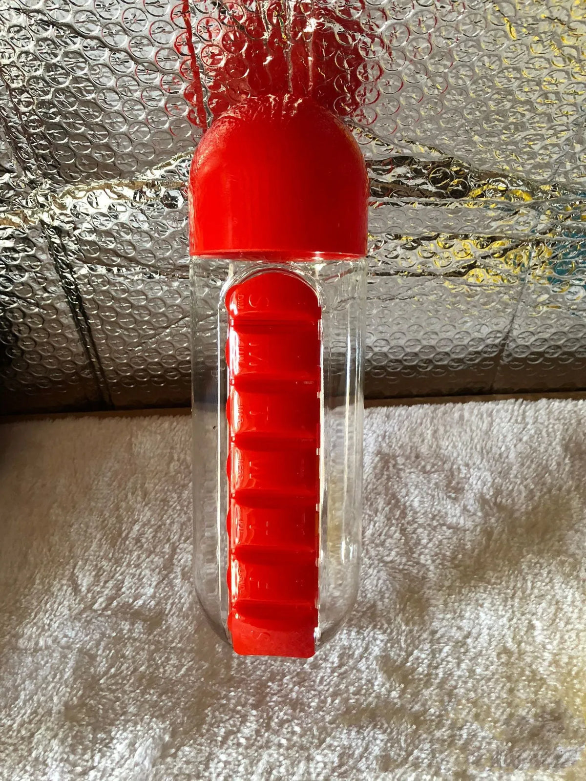 Water bottle with seven pill compartments attached, showing 600ml capacity and BPA-free construction