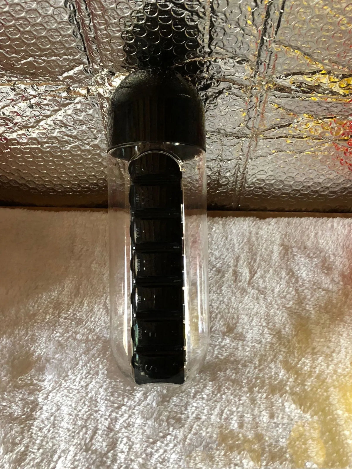 Water bottle with seven pill compartments attached, showing 600ml capacity and BPA-free construction