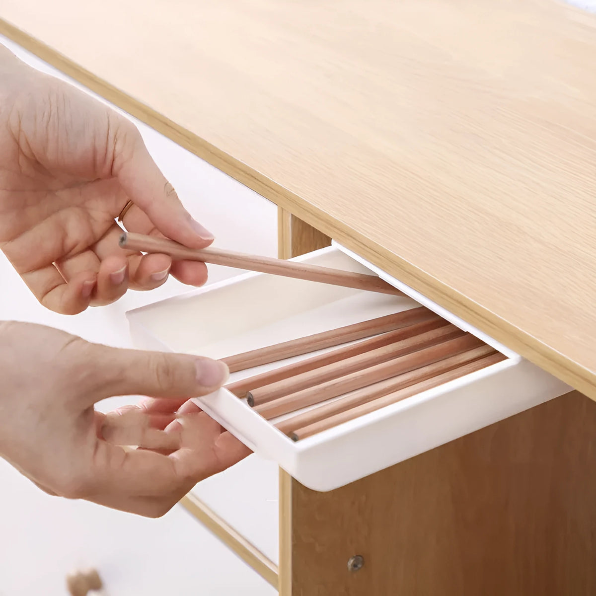 Japanese style plastic drawer storage box in grey and white colours placed under a table