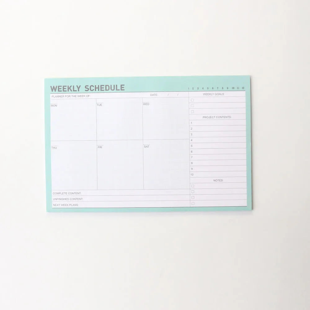 Paper brick desk organiser pad showing weekly and monthly planning sections with pink and green mixed colours