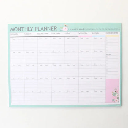 Paper brick desk organiser pad showing weekly and monthly planning sections with pink and green mixed colours