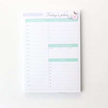 Paper brick desk organiser pad showing weekly and monthly planning sections with pink and green mixed colours