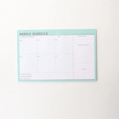 Paper brick desk organiser pad showing weekly and monthly planning sections with pink and green mixed colours