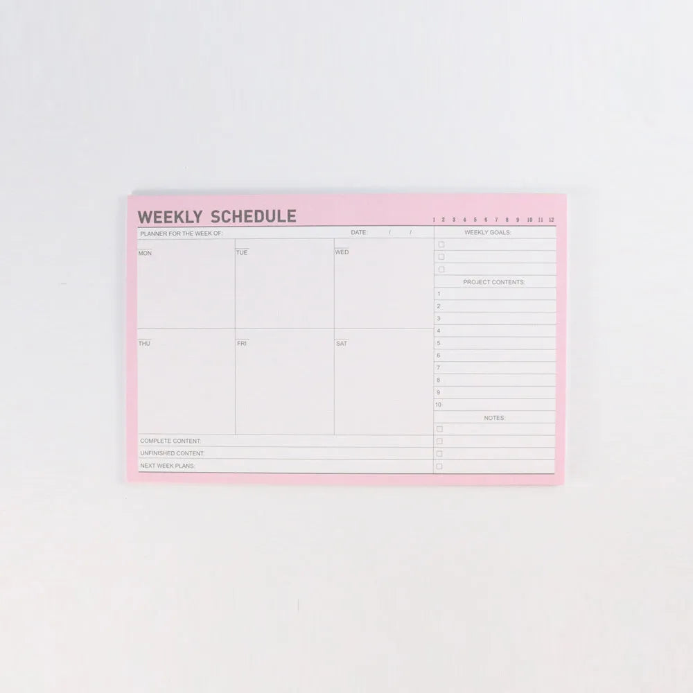 Paper brick desk organiser pad showing weekly and monthly planning sections with pink and green mixed colours